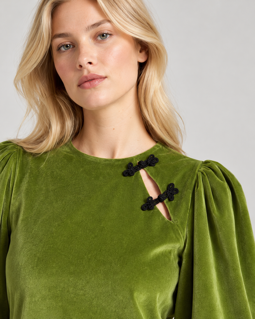 Détail de l'encolure et des brandebourgs noirs de la robe Olivia en velours vert prairie